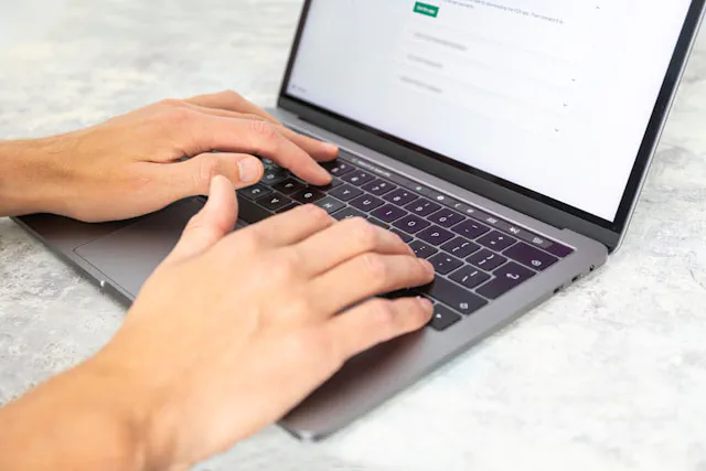 Small business owner reviewing customer enquiries on a laptop