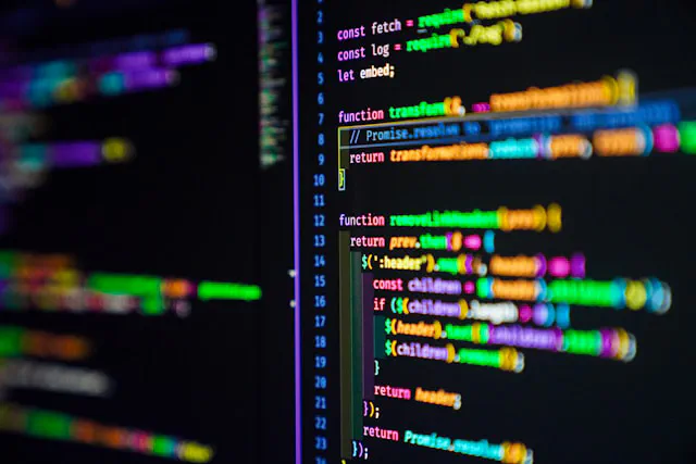 Close-up of a computer screen displaying colorful code lines against a black background.