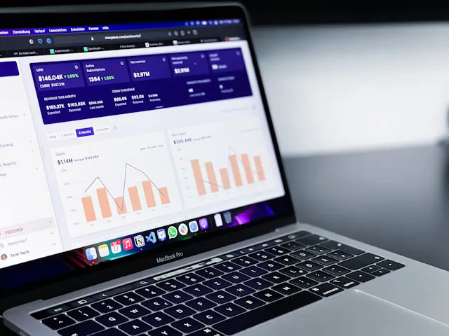 Laptop displaying analytical dashboard with graphs and statistics.