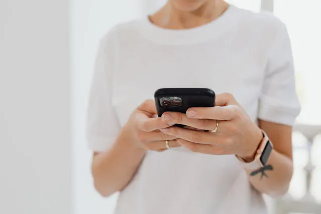A customer holding a phone while reviewing a business website